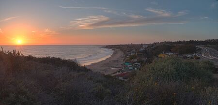 Cottages along Crystal Cove Beach, on the Newport Beach and Laguna Beach line in Southern California at sunset with a rainstorm looming.の写真素材