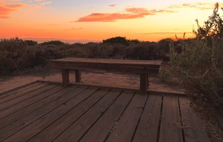 Boardwalk bench at Crystal Cove beach at sunset in the summerの写真素材