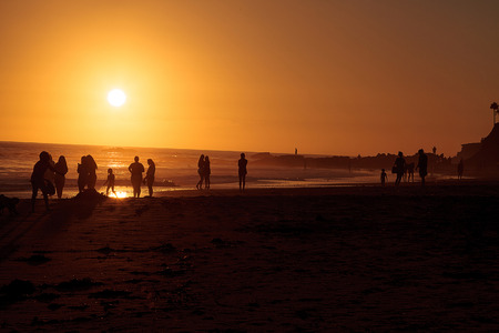 Silhouette of people enjoying the beach at sunset in Southern Californiaのeditorial素材