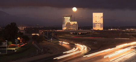 Irvine, California, USA â October 15, 2016: Full moon over a California highway with headlight trails near at sunset.のeditorial素材