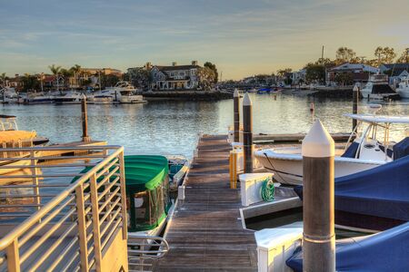 Balboa Island harbor at sunset with ships and sailboats visible from the bridge that leads into Balboa Island, Southern California, USAの写真素材