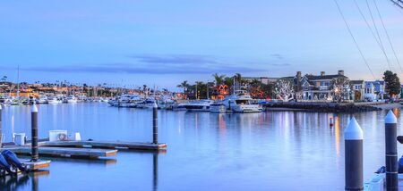 Christmas lights in Balboa Island harbor with ships and sailboats in front of decorated homes in Southern California, USAの写真素材