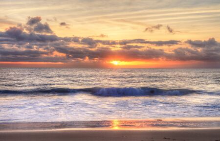 Sunset over the ocean at One Thousand Steps Beach in Laguna Beach, California, USAの写真素材