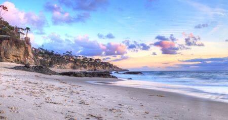 Sunset over the coastline of One Thousand Steps Beach with tidal pools and cliffs in Laguna Beach, California, USAの写真素材