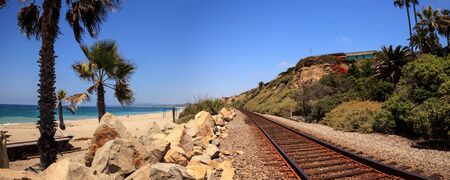 Train tracks run through San Clemente State Beach in Southern California in summer.の写真素材