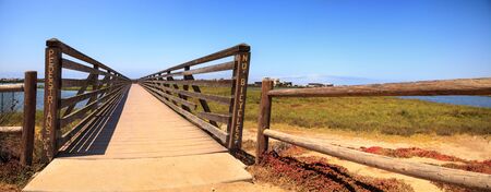 Bridge along the peaceful and tranquil marsh of Bolsa Chica wetlands in Huntington Beach,...