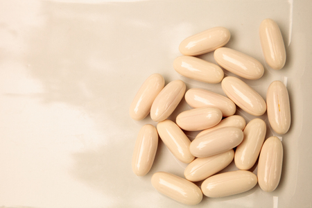 White gel capsules of vitamin Co Q-10 also called coenzyme q10 displayed on a white surface.の写真素材