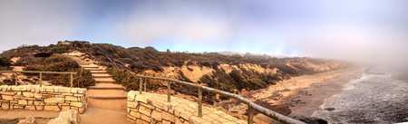 Fog drifts in over the ocean at Crystal Cove state beach on the edge of Laguna Beach and Corona del Mar, California in fall.の写真素材