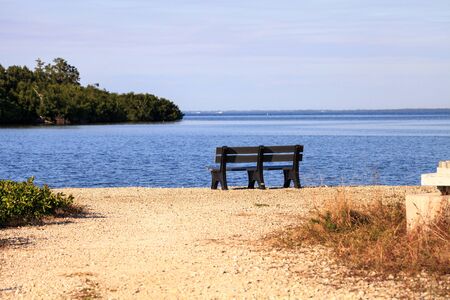 Secluded bench overlooking a large wetland marsh in the Ding Darling National Refuge on Sanibel Island, Floridaの写真素材
