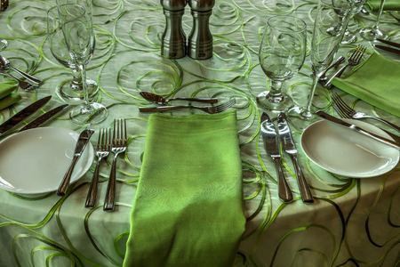 Spring green colored table place setting with a fork, knife, spoon and napkin.の写真素材