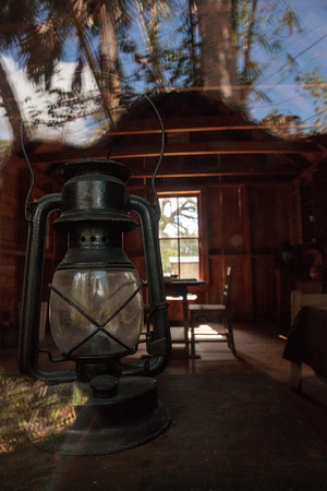 Estero, Florida, USA - February 23, 2019:  Window reflection on 1882 Damkohler Cottage at historic Koreshan State Park.のeditorial素材