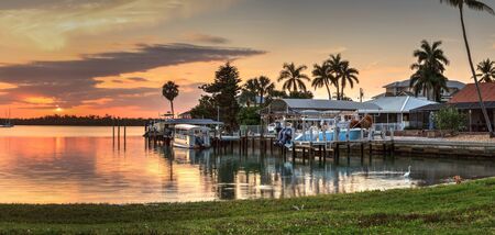Sailboats in a riverway that leads to the ocean on Isle of Capri near Marco Island, Florida at Sunset.の写真素材