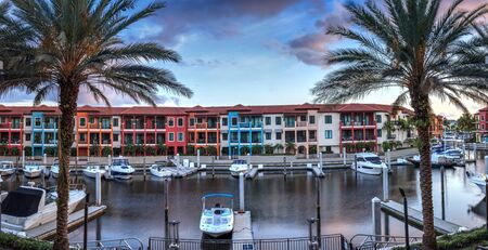 Naples, Florida, USA â May 29, 2019: Colorful buildings and a harbor of boats along a waterway in Naples, Florida.の写真素材