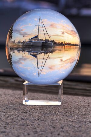 Bright Crystal ball view of Sunset over the boats in Esplanade Harbor Marina in Marco Island,...