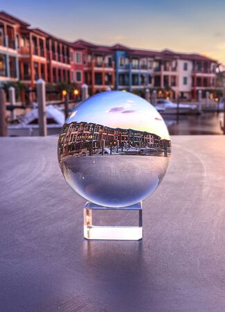 Naples, Florida, USA â May 29, 2019: Crystal ball with colorful buildings and a harbor of boats along a waterway in Naples, Florida inside.の写真素材