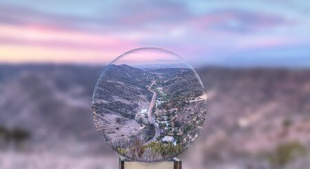 Winding Laguna Canyon road at sunset through a crystal ball as it cuts through the mountains in Laguna Beach, California.の写真素材