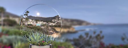 Full moon glows over the coastline of Montage and Treasure Island Beach through a crystal ball in Laguna Beach, California.の写真素材