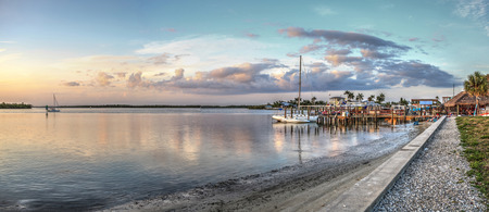 Sailboats in a riverway that leads to the ocean on Isle of Capri near Marco Island, Florida at Sunset.のeditorial素材