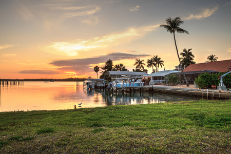 Sailboats in a riverway that leads to the ocean on Isle of Capri near Marco Island, Florida at Sunset.のeditorial素材