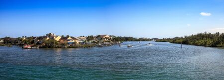 Loxahatchee River with the Jupiter Inlet Lighthouse in the background along with boats in Jupiter, Florida.の写真素材