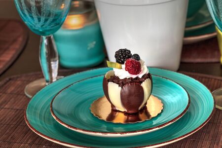 White and dark chocolate mousse dessert with whipped cream and fruit on top.
