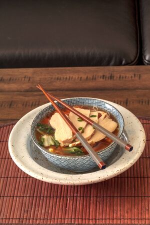 Asian chicken noodle soup with chopsticks and beer.