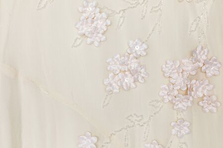 Ivory wedding fabric with flower and beaded background texture.の写真素材