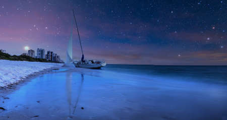 Night sky over shipwreck on the coast of Clam Pass in Naples, Floridaの写真素材