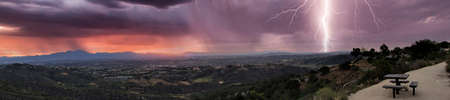 Lightning flashes over the mountains from the Top of the World in Laguna Beach, California at sunrise.の写真素材