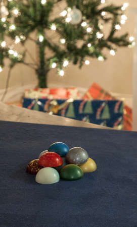 Colorful chocolates on blue background around the Christmas Holiday season.