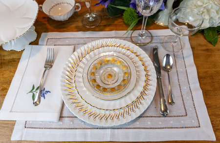 Gold and white fine porcelain place setting with crystal etched in gold on an Easter table.