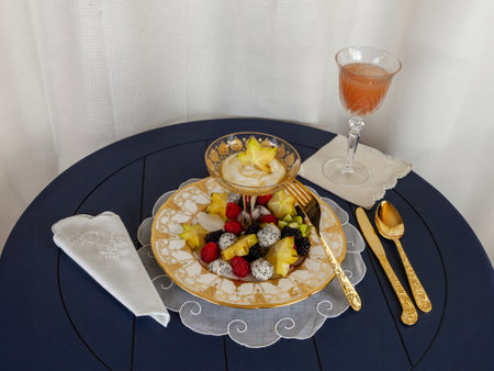 Fancy fruit salad with dragon fruit, star fruit, raspberries, blackberries, and kiwi on a gold encrusted plate with Greek yogurt.の写真素材