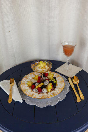 Fancy fruit salad with dragon fruit, star fruit, raspberries, blackberries, and kiwi on a gold encrusted plate with Greek yogurt.の写真素材