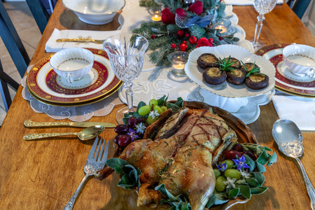 Roasted duck on a platter with sage leaves and grapes on a formal table setting at Christmas.の写真素材