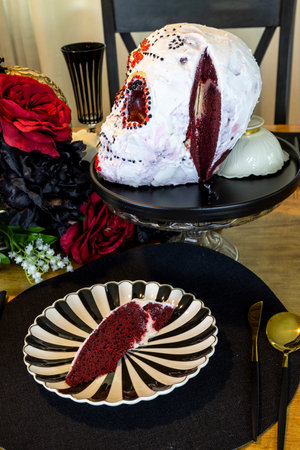Red Velvet cake in the shape of a decorated skull on an All Saints Day decorated table.の写真素材