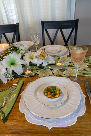 Green kiwi berry, grape and kumquat tart with passion fruit curd on a cookie crust on a fine China plate and silverware.の写真素材