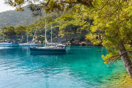 Sailing yachts stay at anchor at calm bay