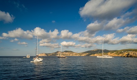 Sailing yachts stays at anchor in Mediterranean sea bay. Balearic islands, Spainの写真素材