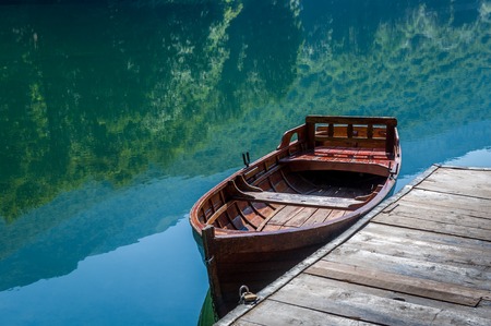 Traditional wooden boat, sky and forest reflected in the mirror water of the Biogradsko lake. National park Biogradska gora, Montenegro.の写真素材