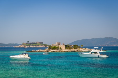 Luxury motor yachts at anchor near the old fortress on a small island. Fort Mirista bay, Montenegro.