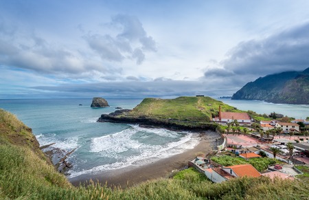 Panoramic aerial view of Porto da Cruz town. Alagoa surfer's beach, rum factory and fortress ruins on the cape. Madeira island north coast, Portugal.の写真素材