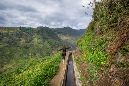 Woman hiker at Levada Nova mountain hiking path near Lombada village. Ponta do Sol, Madeira island, Portugal.の写真素材