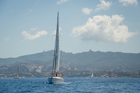 Cruising yacht in a blue waters of Mediterranean sea. Porto Cervo, Sardinia, Italy.