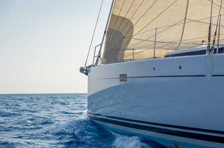 Sailing yacht bow with hoisted headsail, view from she's tender. Mediterranean sea, Sardinia, Italy.の写真素材