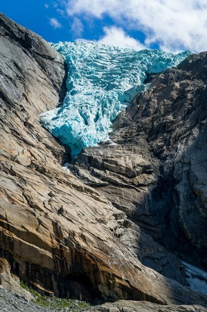 Vertical photo with close view of Briksdalsbreen glacier, turquoise ancient ice in the rocky mountains. Briksdal, Norway.の写真素材
