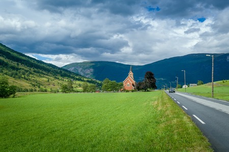 Small church and road in norwegian fields. Rural country landscapes of Norway.の写真素材