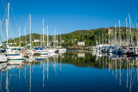 Tarbert marina at perfect summer evening with lots of sailing boats. Hebrides, Scotland.の写真素材
