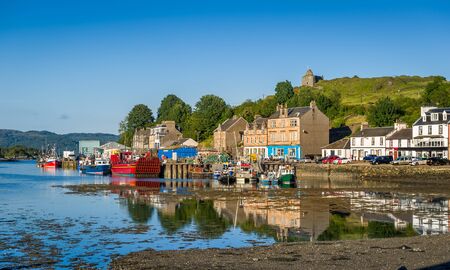 Tarbert pier with fisherman's boats and ferry. Low tide water and evening light. Scotland.の写真素材