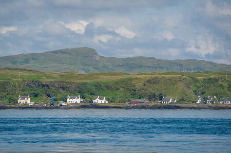 Village at Scotland shore view from the water. Typical rural landscape of Hebrides islands.の写真素材