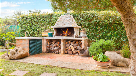 External Wood oven with burning fire and firewood External Wood oven with burning fire and firewood